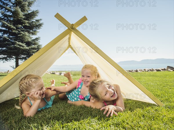 Three girls (2-3, 4-5) playing in tent