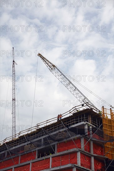 Cranes against cloudy sky