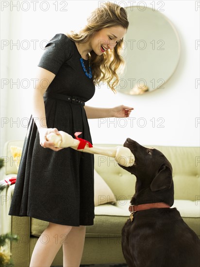 Young woman giving to dog Christmas present