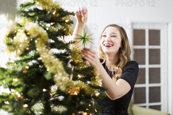 Young woman decorating Christmas tree