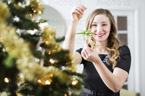 Young woman decorating Christmas tree