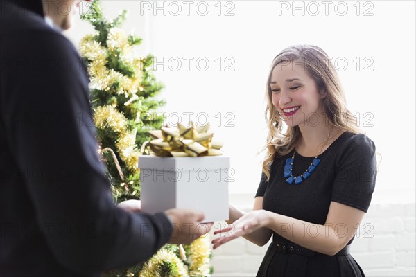 Man giving present to woman at Christmas