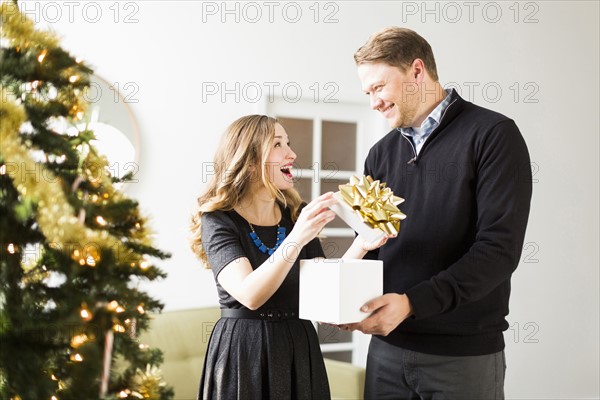 Woman opening present from man