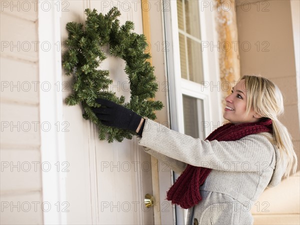 Young woman hanging wreath