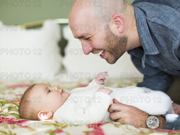 Studio shot of father smiling to his son (2-5 months)