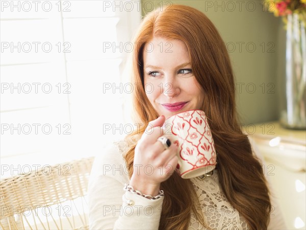 Mid adult woman drinking from coffee mug