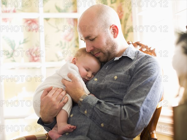 Mid adult man watching his son (2-5 months) sleeping