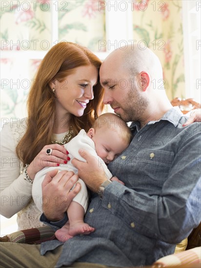 Parents holding their sleeping baby (2-5 months)