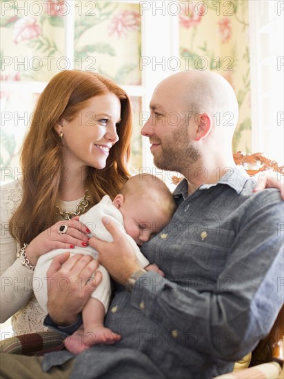 Parents holding their sleeping baby (2-5 months)