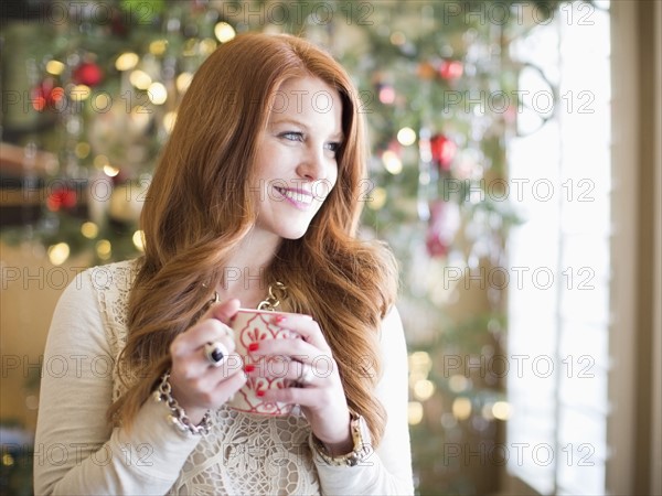 Mid adult woman with coffee mug in christmas time