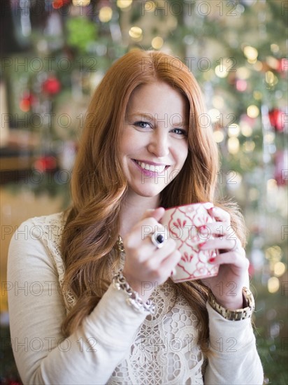 Mid adult woman with coffee mug in christmas time