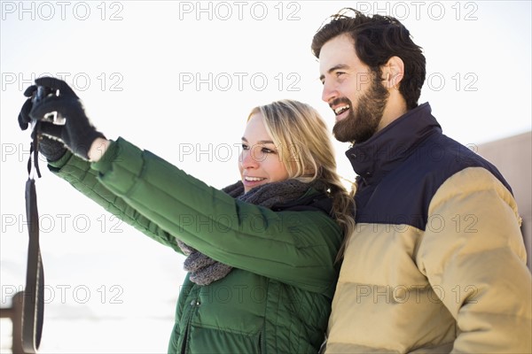 Woman photographing herself and man