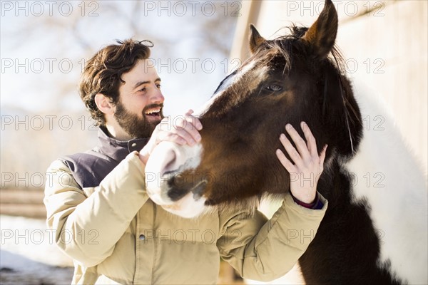 Man stroking horse