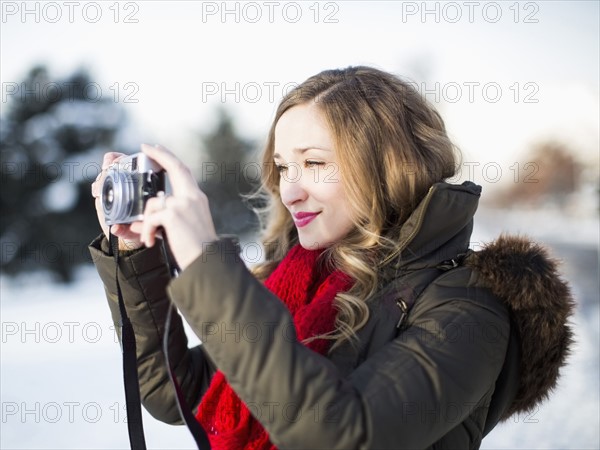 Woman photographing winter landscape