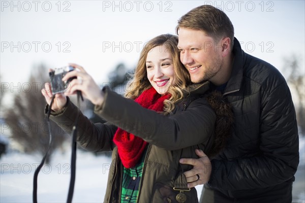 Woman photographing herself and man