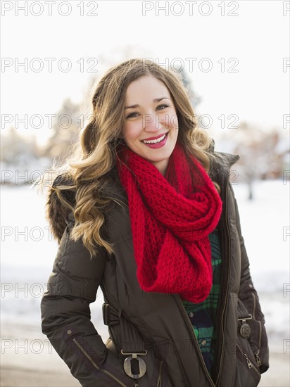 Portrait of woman wearing red scarf smiling outdoors