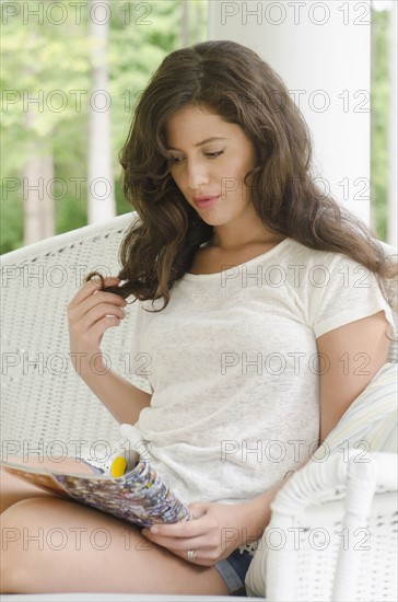 Woman reading magazine on porch