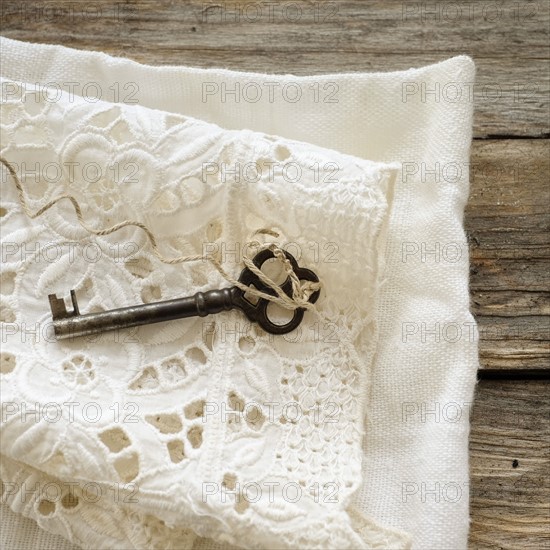 Studio shot of antique key on lace cloth.