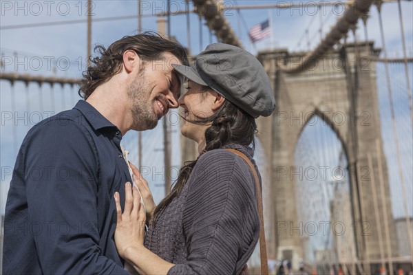 Happy couple kissing on Brooklyn Bridge. Brooklyn, New York.