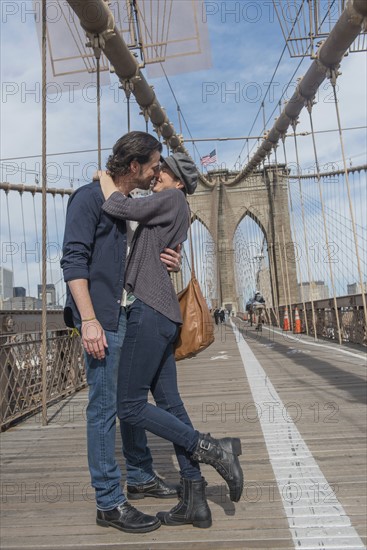 Happy couple kissing on Brooklyn Bridge. Brooklyn, New York.