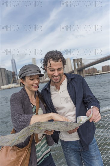 Happy couple reading map. Brooklyn, New York.