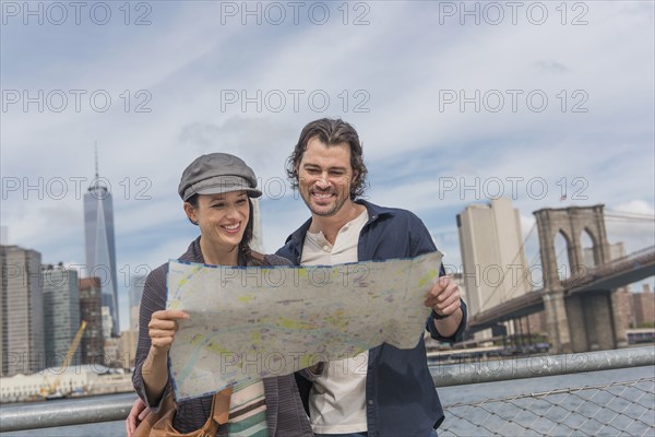 Happy couple reading map. Brooklyn, New York.