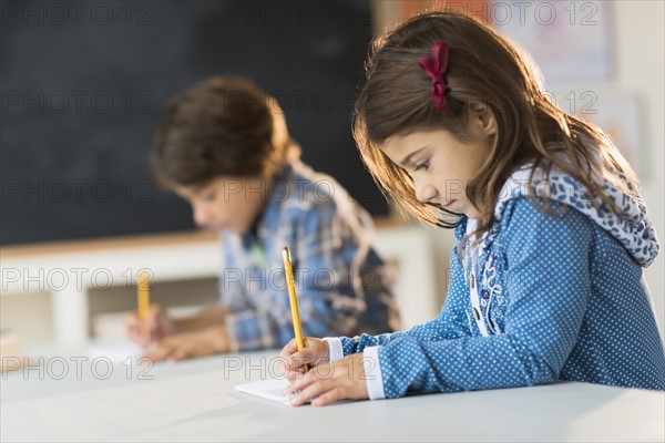 Pupils (6-7) learning in classroom.