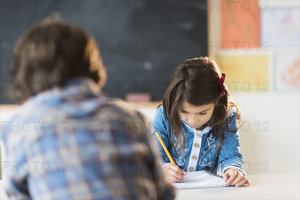 Pupils (6-7) learning in classroom.