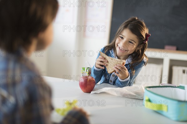 Pupils (6-7) eating lunch in classroom.