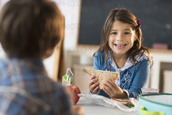 Pupils (6-7) eating lunch in classroom.