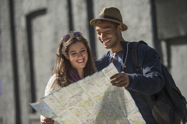 Couple reading map on street.
