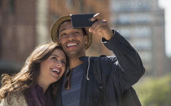 Couple taking selfie on street. .