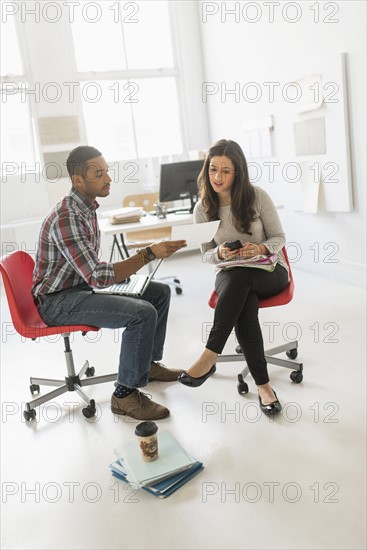 Couple sitting and working in office.