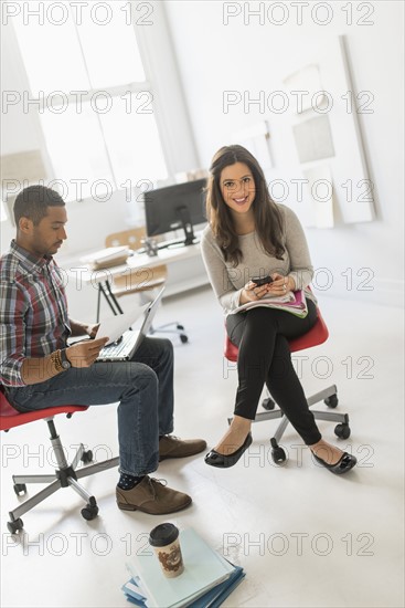Couple sitting and working in office.