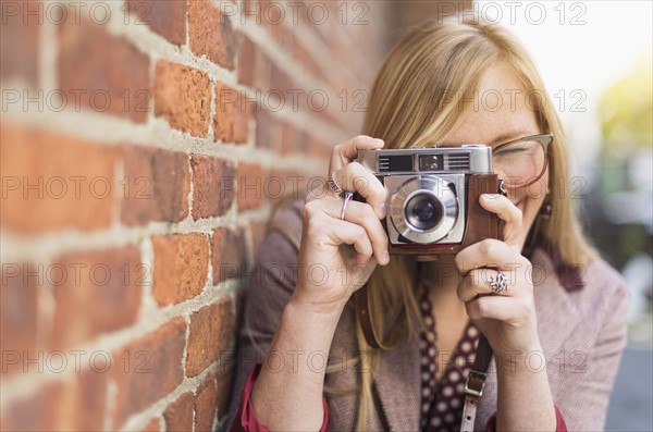 Woman photographing with vintage camera. .