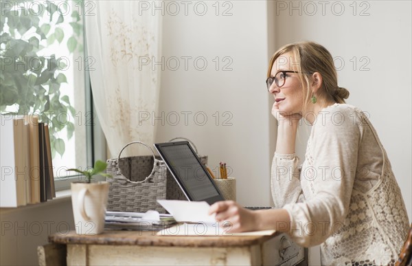 Woman sitting at desk and contemplating. .