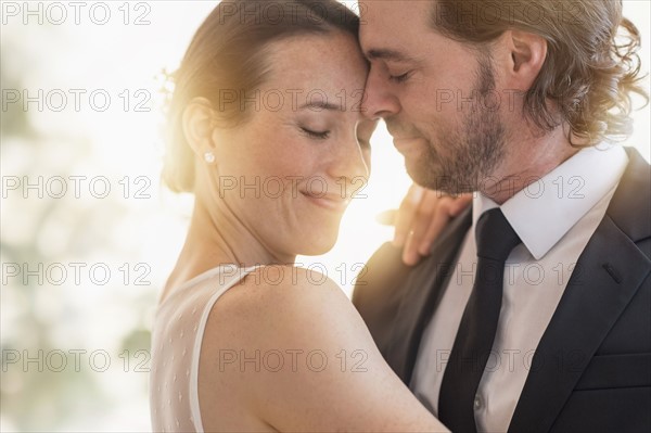 Bride and groom dancing cheek to cheek.