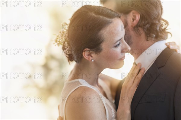 Bride and groom dancing cheek to cheek.