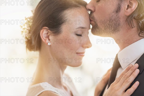 Groom kissing bride. .