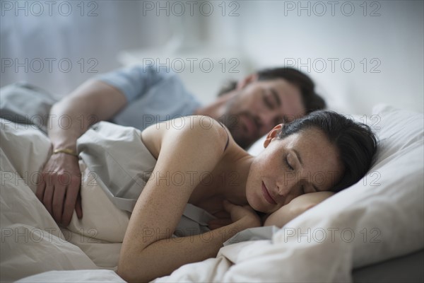 Couple sleeping together in bed at night.