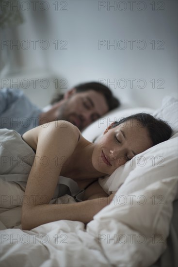 Couple sleeping together in bed at night.