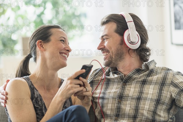 Cheerful couple listening to music at home.