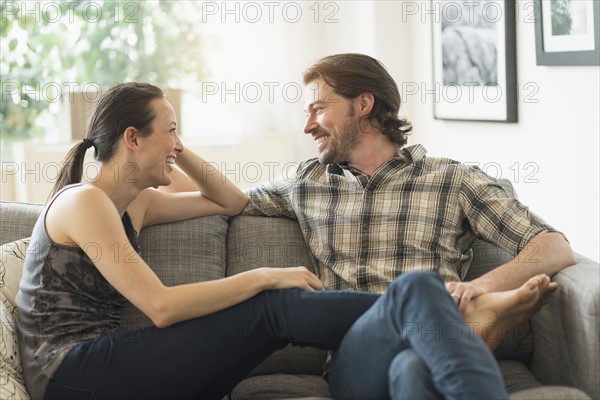 Cheerful couple relaxing on sofa.