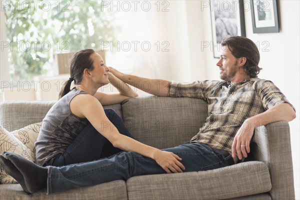 Cheerful couple relaxing on sofa.