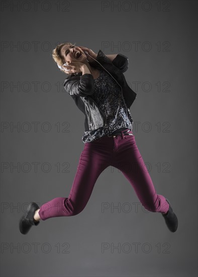 Studio shot of woman jumping.