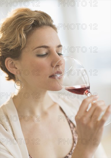 Young woman drinking red wine.