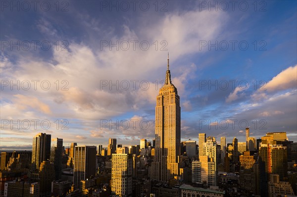 Cityscape with Empire State Building at sunset. New York City, New York.