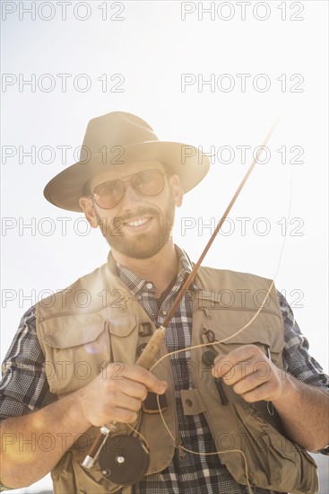 Portrait of man holding fishing rod.