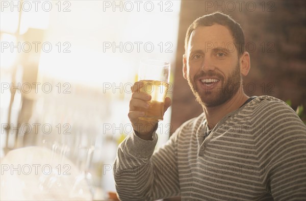 Portrait of man having drink in bar.