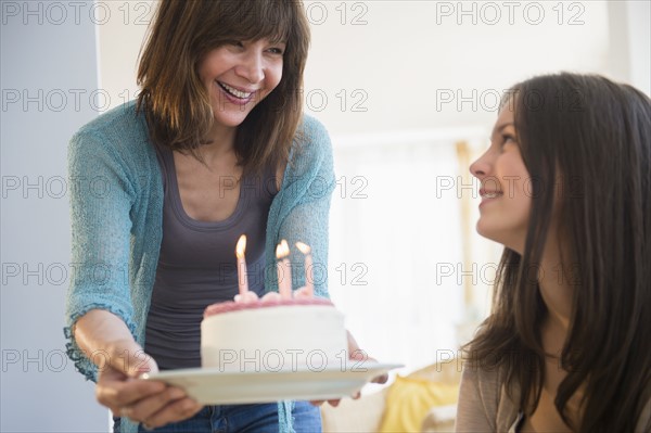 Teenage girl (14-15) celebrating birthday with her mom at home